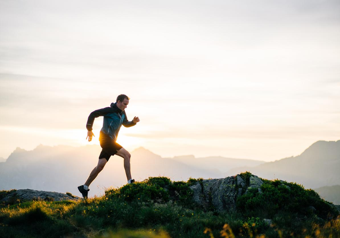 Jogger op heuvel bij zonsopgang